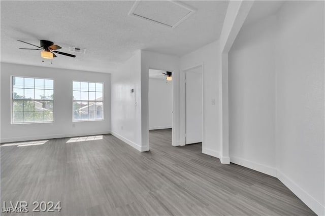 unfurnished room with hardwood / wood-style flooring and a textured ceiling