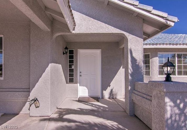 view of exterior entry featuring a patio area