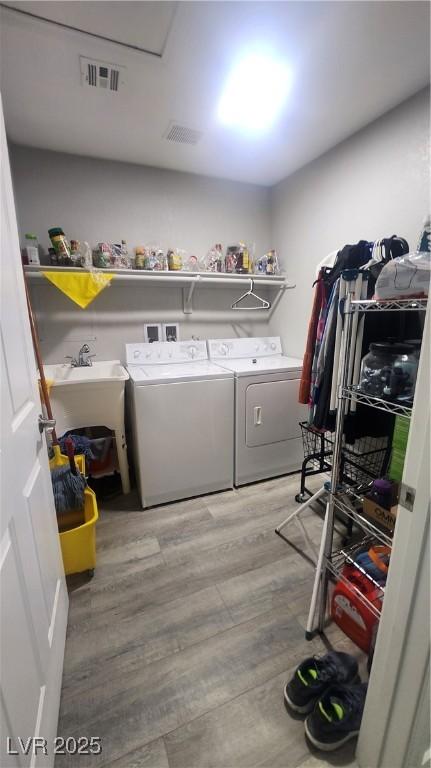 laundry room featuring separate washer and dryer and light hardwood / wood-style flooring