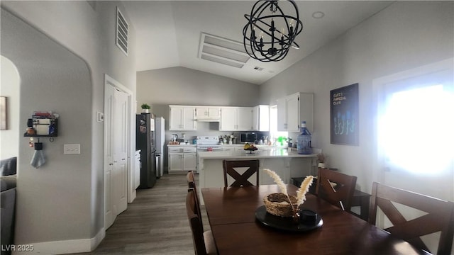 dining room featuring high vaulted ceiling, dark hardwood / wood-style floors, and a chandelier