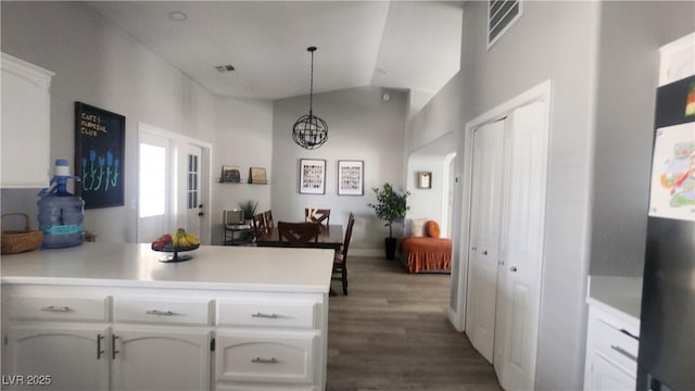 kitchen with decorative light fixtures, white cabinets, hardwood / wood-style flooring, kitchen peninsula, and an inviting chandelier