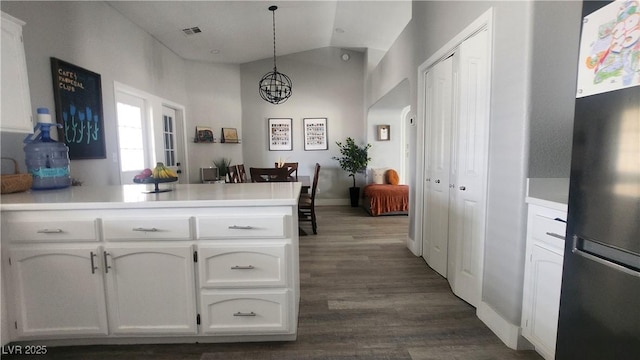 kitchen with stainless steel refrigerator, white cabinets, dark hardwood / wood-style flooring, decorative light fixtures, and kitchen peninsula