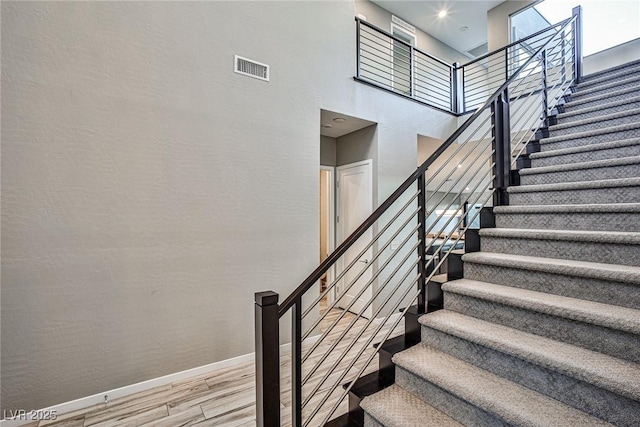 stairway featuring a high ceiling