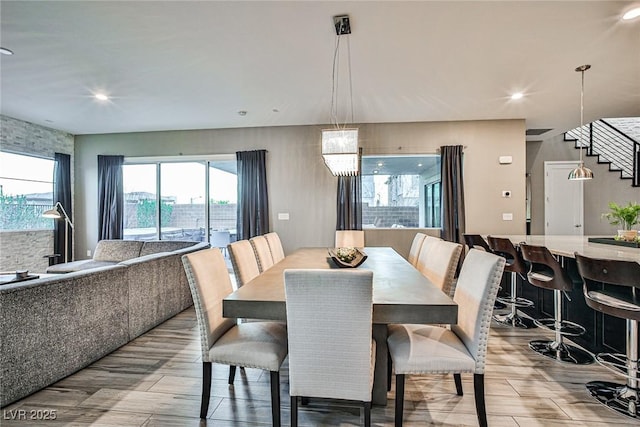 dining area with light hardwood / wood-style flooring and a notable chandelier