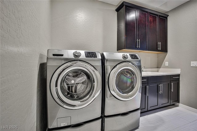 laundry room featuring washer and dryer, cabinets, and sink