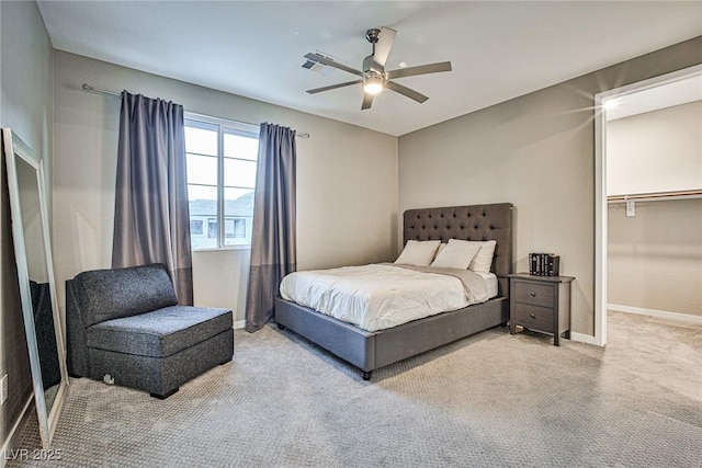 carpeted bedroom with ceiling fan, a spacious closet, and a closet