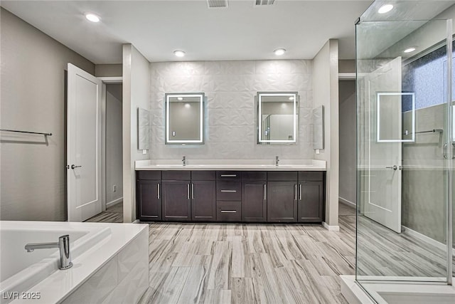 bathroom with vanity, hardwood / wood-style flooring, and separate shower and tub