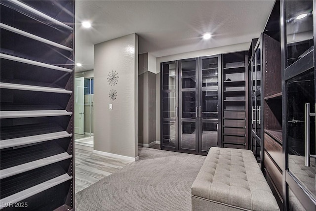 walk in closet featuring light carpet