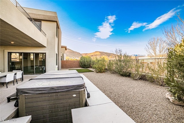 view of patio featuring a mountain view and a hot tub