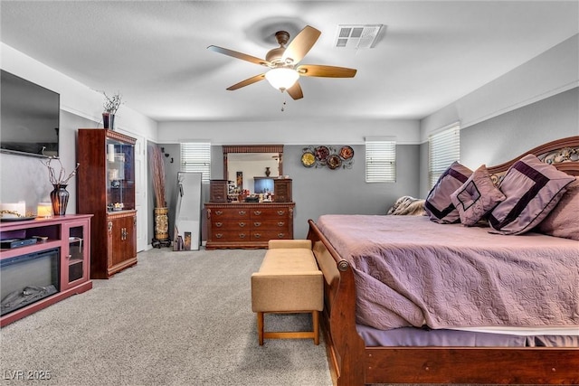 bedroom featuring carpet, multiple windows, and ceiling fan