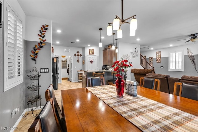 dining area with ceiling fan with notable chandelier