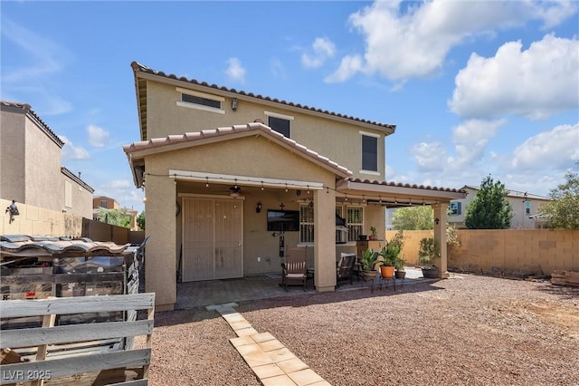 back of property featuring ceiling fan and a patio