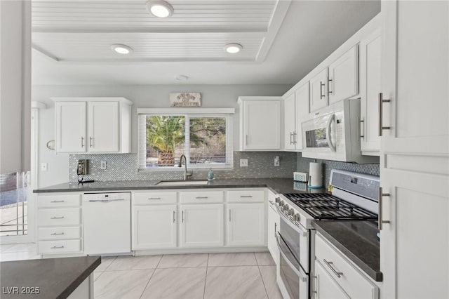 kitchen with white cabinets, white appliances, tasteful backsplash, and sink