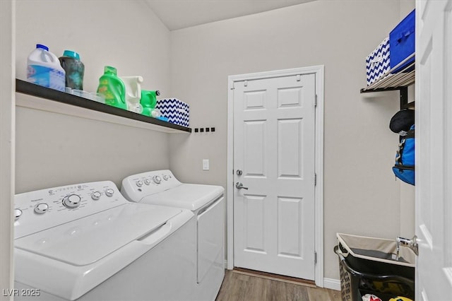 clothes washing area with washing machine and dryer and light hardwood / wood-style floors