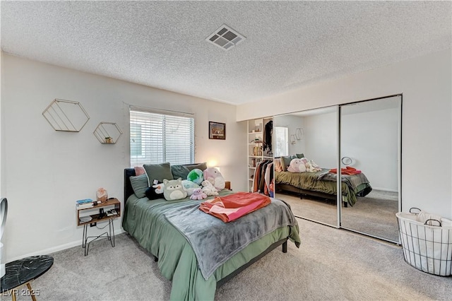 bedroom with a closet, carpet, and a textured ceiling