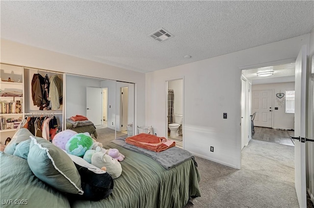 bedroom featuring connected bathroom, a textured ceiling, light carpet, and a closet