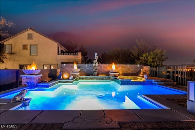 pool at dusk with an in ground hot tub and an outdoor fire pit