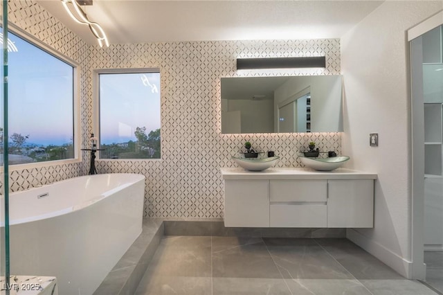 bathroom with tasteful backsplash, a tub to relax in, and vanity