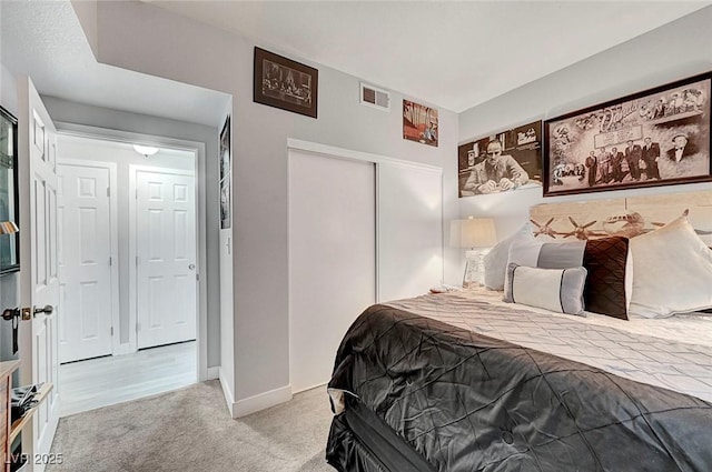 bedroom featuring light colored carpet and a closet