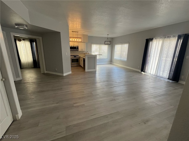 unfurnished living room with a textured ceiling and light wood-type flooring