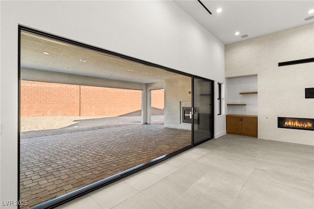 interior space featuring a towering ceiling and a tiled fireplace