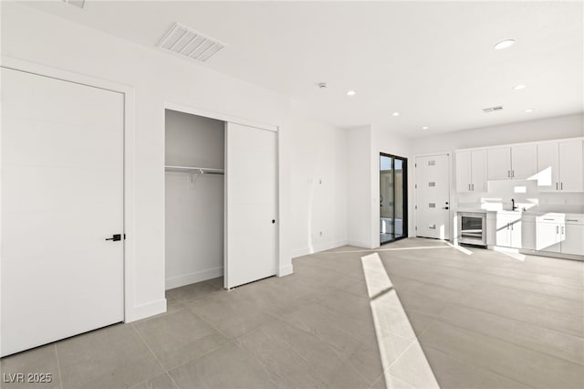 interior space with white cabinets, beverage cooler, and light tile patterned floors