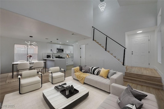 living room featuring light hardwood / wood-style floors, an inviting chandelier, and sink