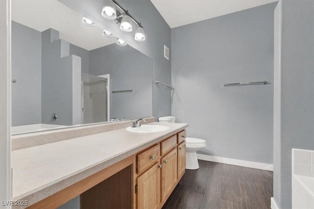 bathroom with wood-type flooring, vanity, toilet, and walk in shower