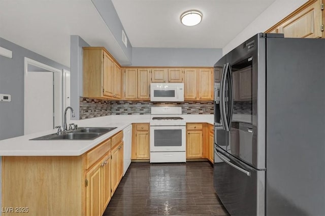 kitchen with sink, light brown cabinets, tasteful backsplash, kitchen peninsula, and white appliances