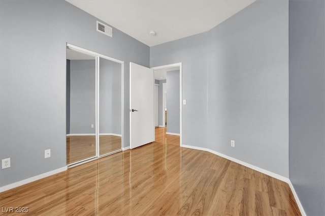 unfurnished bedroom featuring wood-type flooring and a closet