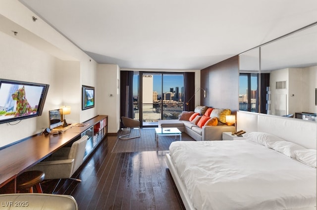 bedroom with multiple windows, access to outside, dark hardwood / wood-style floors, and floor to ceiling windows