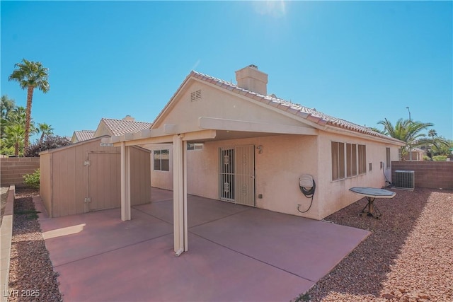 rear view of property featuring a patio, a shed, and central AC unit