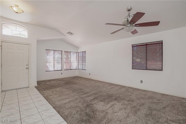 foyer entrance featuring a wealth of natural light, light tile patterned floors, vaulted ceiling, and ceiling fan