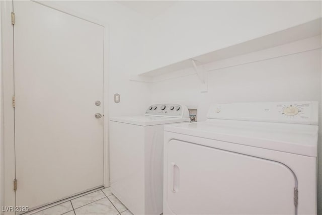 laundry area with light tile patterned floors and washing machine and clothes dryer