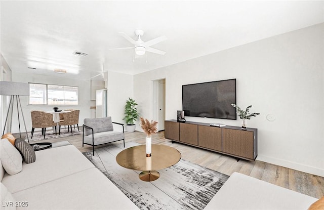 living room with ceiling fan and light hardwood / wood-style floors