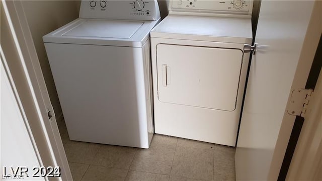 laundry room with separate washer and dryer and light tile patterned flooring