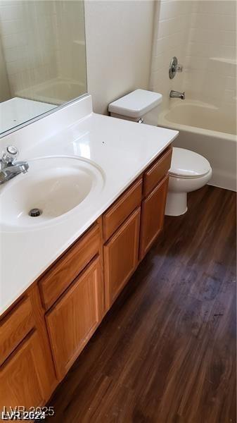 full bathroom with hardwood / wood-style flooring, vanity, toilet, and shower / tub combination