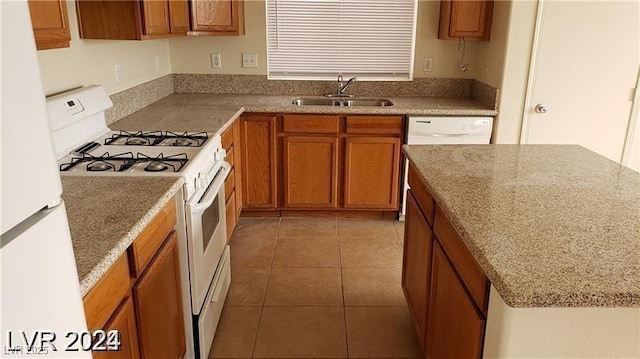 kitchen with light stone counters, sink, light tile patterned floors, and white appliances