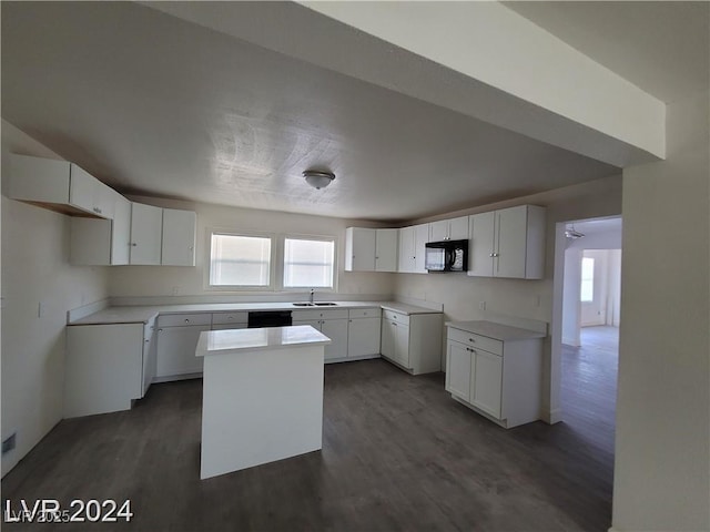 kitchen with black appliances, a center island, white cabinetry, and sink