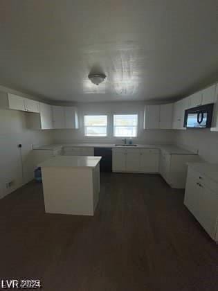 kitchen featuring white cabinets, a center island, and sink