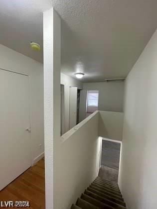 stairway featuring hardwood / wood-style floors and a textured ceiling