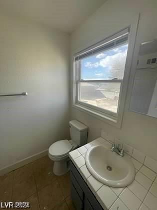 bathroom with tile patterned flooring, vanity, and toilet