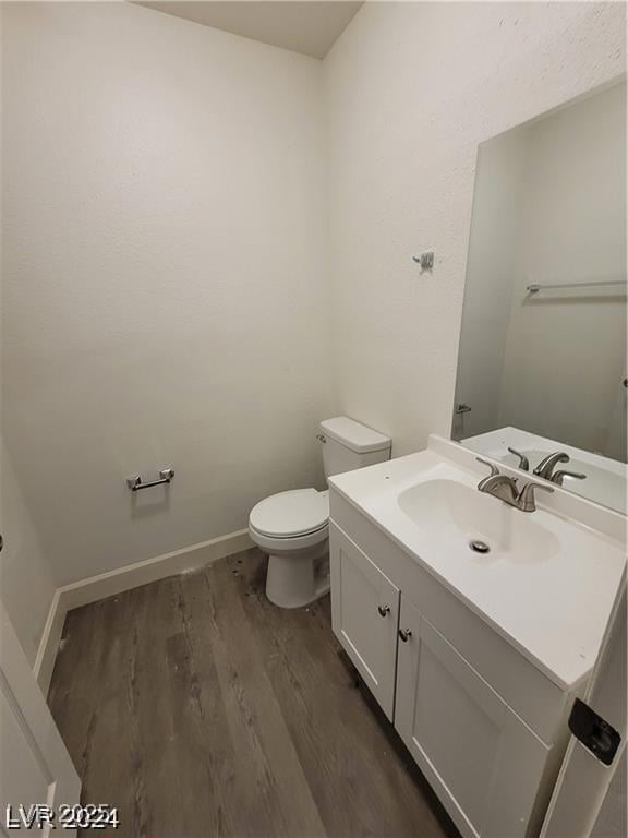 bathroom featuring hardwood / wood-style floors, vanity, and toilet