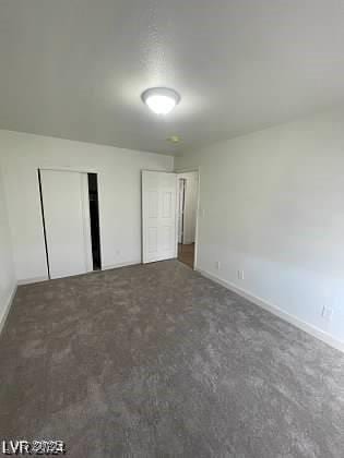 unfurnished bedroom featuring dark colored carpet