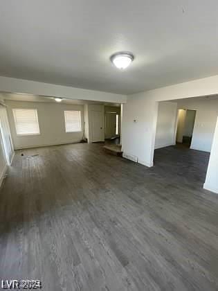 unfurnished living room with dark hardwood / wood-style flooring