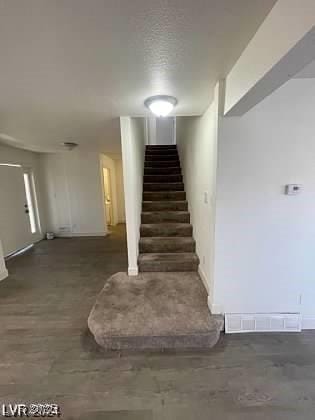 stairs with a textured ceiling