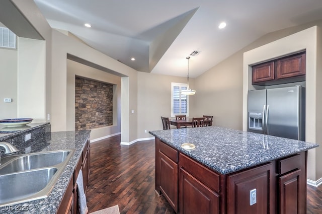 kitchen featuring stainless steel fridge, dark hardwood / wood-style flooring, lofted ceiling, pendant lighting, and sink