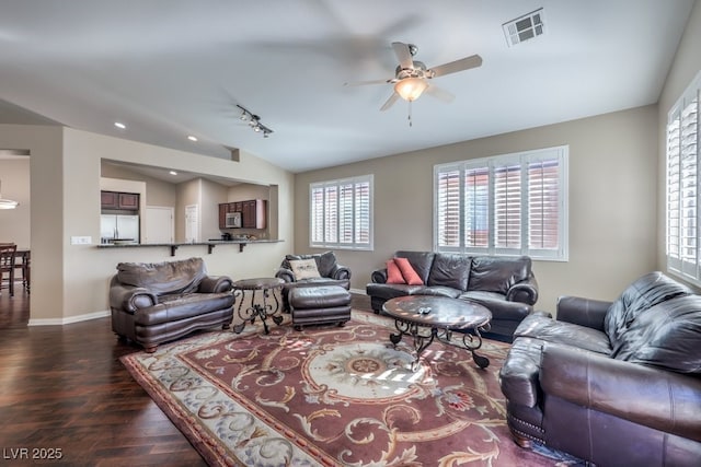 living room with ceiling fan, vaulted ceiling, dark hardwood / wood-style floors, and track lighting