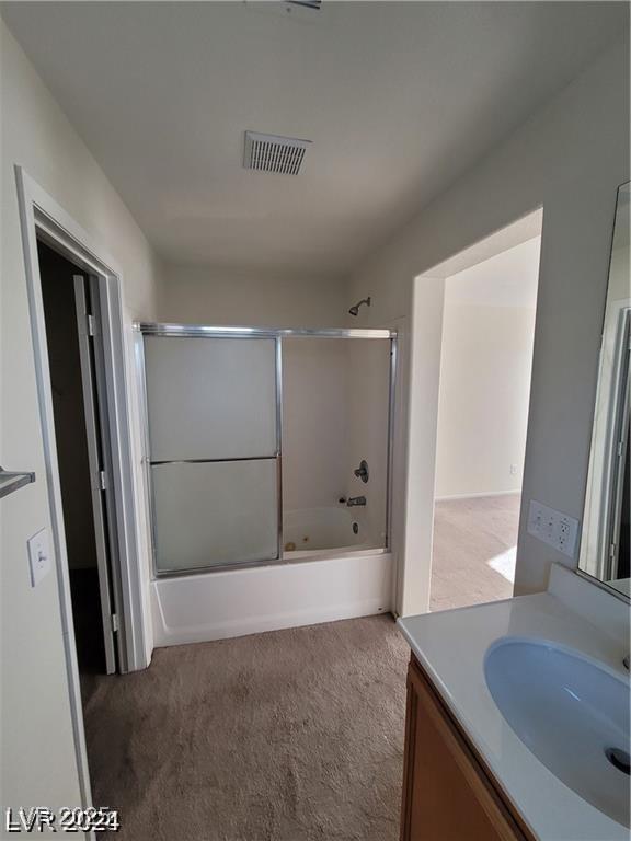 bathroom with vanity and enclosed tub / shower combo