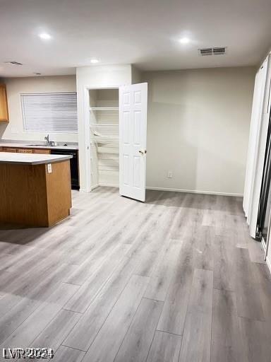 interior space featuring dishwasher, light hardwood / wood-style floors, and sink